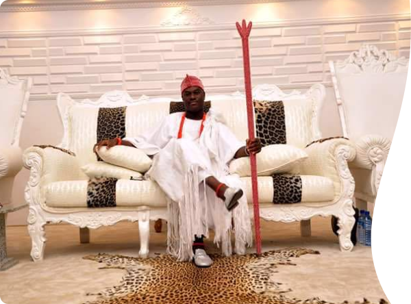 black american sitting on a couch with a stick
