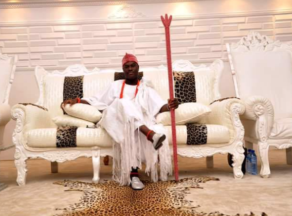 black american sitting on a couch with a stick